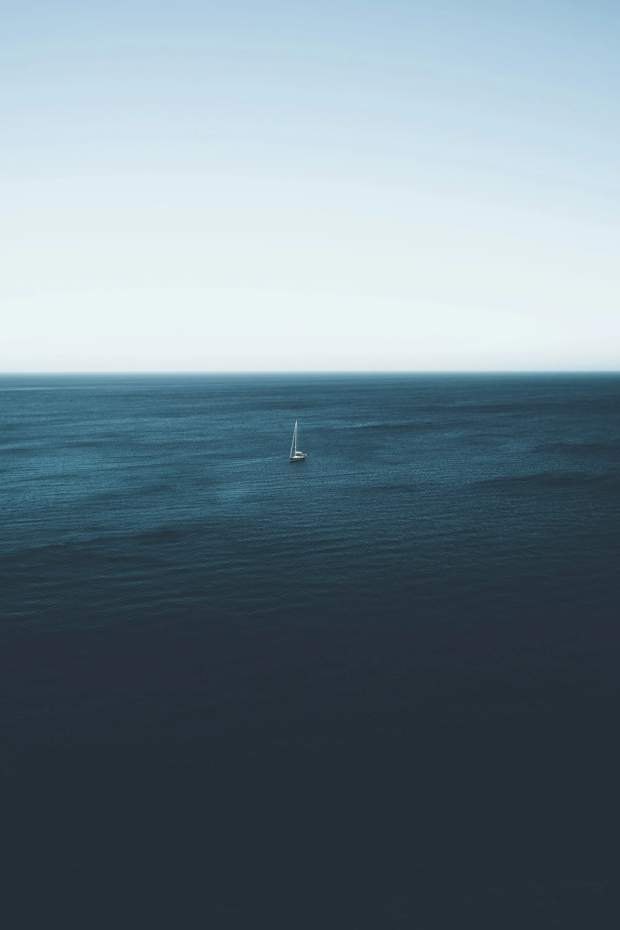 Weite Wasserfläche mit einem Segelboot am Horizont
